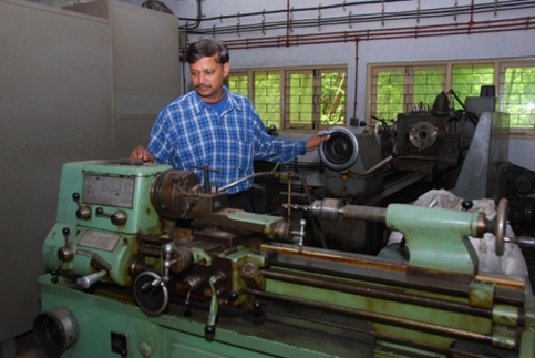 Technician operating a lathe machine